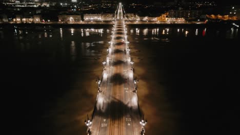 Illuminated-Pont-de-Pierre,-Garonne-River,-Bordeaux---aerial-flyover