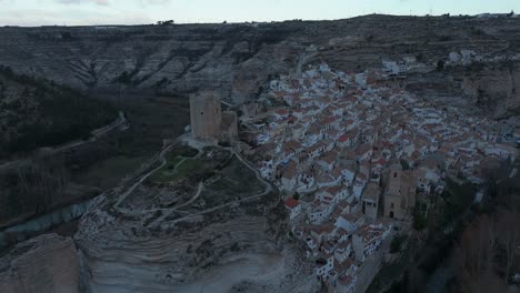Orbiting-drone-movement-the-castle-of-the-medieval-village-of-Alcalá-del-Jucar,-Spain,-one-of-the-most-beautiful-villages-in-Spain