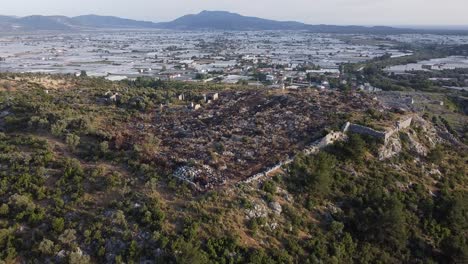 Approaching-drone-shot-over-the-ruins-of-Sillyon,-an-ancient-fortress-near-Attaleia-in-Pamphylia,-showing-a-modern-town-on-the-southern-coast-of-Turkey