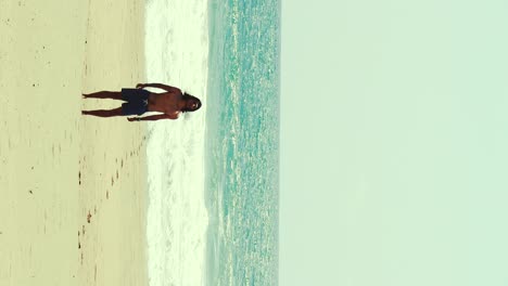 Boy-with-long-hair-in-slow-motion-run-towards-the-ocean-waves