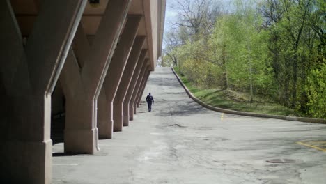 Adulto-Caminando-Por-Una-Carretera-Vacía-En-La-Distancia-Junto-Al-Aparcamiento-Subterráneo-En-Montreal