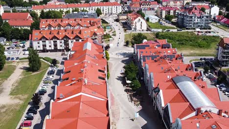 Innenstadt-Von-Gizycko-Und-Gebäude-Mit-Rotem-Dach-An-Sonnigen-Tagen,-Drohnenansicht-Aus-Der-Luft
