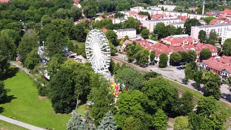 Township-of-Gizycko-with-white-Ferris-wheel,-aerial-orbit-view