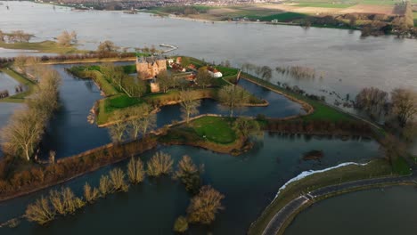 Low-rising-aerial-view-of-historic-Slot-Loevestein-near-Gorinchem-Netherlands-surrounded-by-flood-waters-after-heavy-rains-caused-the-Waal-River-to-overflow-its-banks-in-early-2024