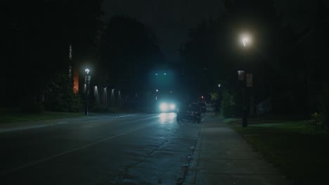 Dark-Lit-Suburban-Street-With-Car-With-Headlights-On-Going-Past