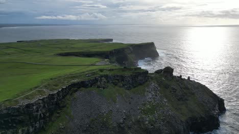 Aerial-tilting-shot-of-a-crumbling-watchtower-at-the-Cliffs-of-Moher