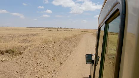 Vehículo-De-Safari-Conduciendo-En-Terreno-árido-En-Masai-Mara,-Kenia
