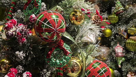 Nahaufnahme-Eines-Weihnachtsbaums-Mit-Schnee,-Geschmückt-Mit-Vielen-Bunten-Kugeln,-Dreht-Sich-Auf-Einem-Drehteller---Hintergrund-Für-Festliche-Winterferien