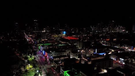 Nightly-aerial-drone-footage-of-Miami,-USA,-rising-pedestal-shot-showing-many-different-colored-lights-over-the-buildings