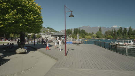 Travelers-At-Queenstown-Marina-Wharf-In-Summer-In-New-Zealand