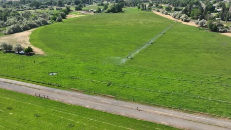 Drone-shot-of-a-sprinkler-system-watering-a-field-of-crops-in-Benton-City,-Washington