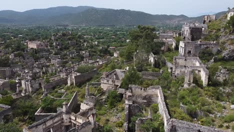 Approaching-drone-shot-over-the-abandoned-houses-of-Kayaköy,-a-UNESCO-World-Friendship-and-Peace-Village,-located-in-the-province-of-Fethiye,-Turkey