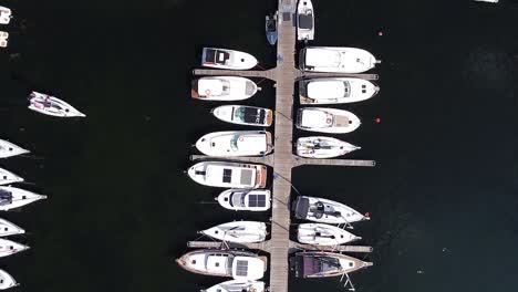 Wooden-pier-walkway-and-yachts,-aerial-top-down-view