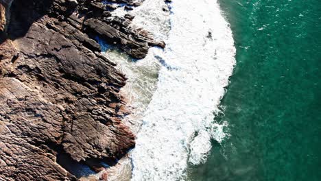 Foamy-Ocean-Waves-Crashing-Rocky-Shoreline-In-Noosa,-Queensland,-Australia---Drone-Shot
