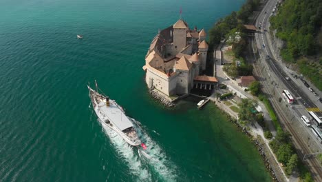 Aerial-Tilt-Reveal-of-Chillon-Castle-and-La-Suisse-Steam-Paddle-Boat-on-Lake-Geneva