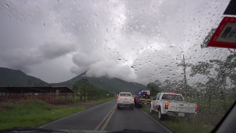 Fahren-Unter-Regen-Und-Stürmischem-Himmel-Und-Vorbeifahrende-Verkehrspolizisten,-Die-Ein-Fahrzeug-Kontrollieren,-Zeitlupe