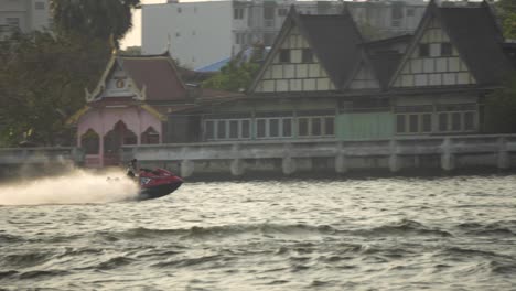 Tracking-shot-of-a-jet-ski-in-a-river-of-a-city-of-Vietnam