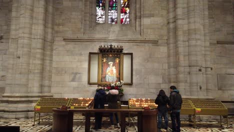 Milano,-Italy---December-30th,-2018:-A-memorial-table-with-candles-at-a-church-in-Milano,-Italy
