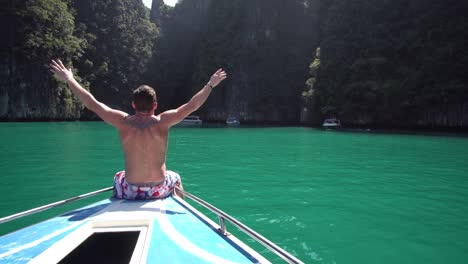 Young-Male-Enjoying-the-View-of-Exotic-Tropical-Lagoon-From-Bow-of-the-Boat