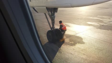 Stuttgart,-Germany---December-29th,-2018:-An-Employee-checking-the-tire-of-the-aircraft-at-the-airport,-Stuttgart,-Germany