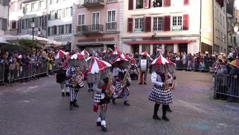 Solothurn,-Suiza---3-De-Marzo-De-2019:-Un-Club-De-Carnaval-Musical-Con-Enormes-Sombreros-Y-Guirnaldas-Tocando-Instrumentos-De-Metal-Mientras-Camina-Por-El-Carnaval