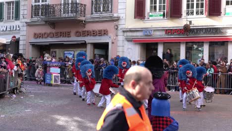Solothurn,-Suiza---03-De-Marzo-De-2019:-Un-Club-De-Carnavales-Musicales-Con-Enormes-Sombreros-Azules-Y-Máscaras-Divertidas-Tocando-Tambores-Mientras-Camina-Por-El-Carnaval