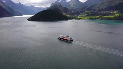 Aerial-view-of-the-Hurtigruten-cruise-ship,-heading-towards-the-Geirangerfjord,-in-Norway---circling,-drone-shot