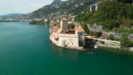 Aerial-Dolly-Out-and-Tilt-Up-of-Chillon-Castle-on-Lake-Geneva