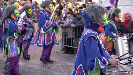 Solothurn,-Suiza---3-De-Marzo-De-2019:-Un-Club-De-Carnavales-Musicales-Con-Máscaras-Coloridas-Tocando-Instrumentos-Musicales-Como-Tambores-Y-Saxo-Mientras-Camina-Por-El-Carnaval