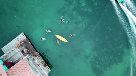 Aerial-shot-of-peopple-swimming-on-turquoise-water-in-Panama