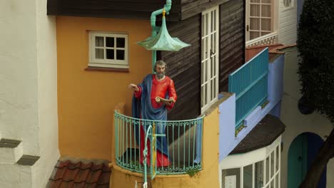 Statue-Of-Saint-Peter-Reading-The-Bible-On-The-Balcony-In-Portmeirion,-North-Wales