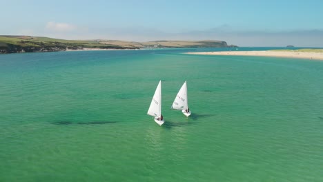 Aerial-Tilt-Shot-of-Two-Small-Sailing-Boats-near-Rock-in-Cornwall