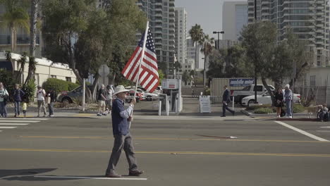 Elderly-veteran-walks-with-American-flag-during-Veteran's-Day-Parade-2019-in-Downtown-San-Diego