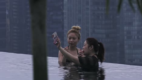 Two-Female-Friends-Posing-For-Photos-At-Infinity-Pool-In-Singapore