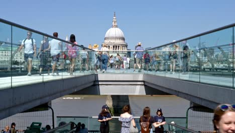 Statische-Perspektivaufnahme-Der-Millennium-Bridge-Mit-Blick-Auf-Die-St.-Paul&#39;s-Cathedral-Mit-Vielen-Fußgängern,-Die-Die-Wackelige-Brücke-überqueren,-London,-Großbritannien,-Sommerzeit
