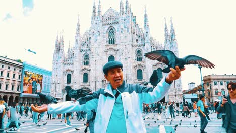 A-chineese-senior-citizen-enjoying-his-vacation-in-Milan-Italy-feeding-the-pigeons