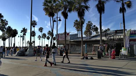 Masked-People-entering-the-world-famous-boardwalk-and-beach-on-a-sunny-day,-in-Venice,-Los-Angeles,-California,-USA---still-view