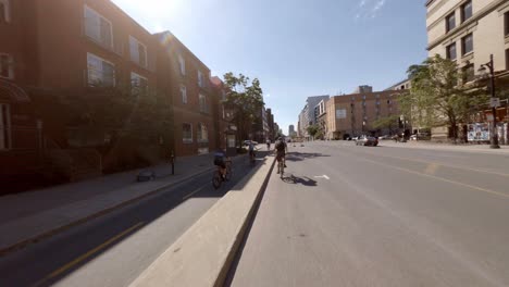 POV-En-Bicicleta-Por-La-Soleada-Calle-Berri-Junto-Al-Carril-Bici-En-Montreal,-Canadá