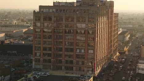 Aerial-rising-mid-shot-of-historic-Bendix-Building-sunlit-and-traffic-on-a-highway-in-the-background