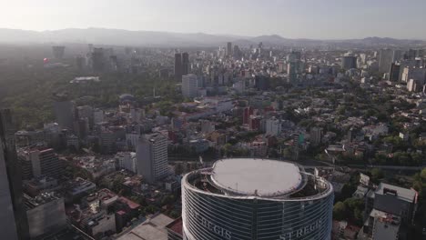 Mexico-City,-Drone-Aerial-View-of-Modern-Downtown-Buildings-and-Misty-Cityscape-on-Sunny-Evening