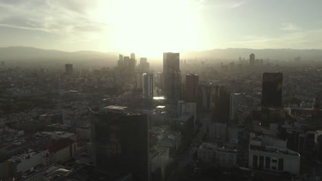 Mexico-City-Downtown-Cityscape,-Cinematic-Aerial-View-on-Golden-Hour-Sunlight-and-Misty-Skyline,-Drone-Shot