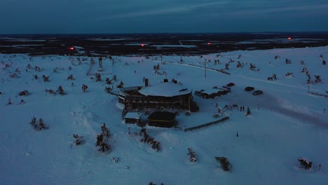 Vista-Aérea-Del-Restaurante-Tuikku,-En-La-Noche-Polar-Levi,-Laponia---órbita,-Disparo-De-Drone