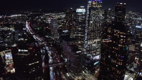 Aerial-View-of-Highway-Traffic-and-Downtown-Los-Angeles-Skyscrapers-at-Night,-California-USA