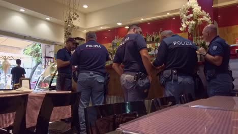 Oficiales-De-Policía-Italianos-Comprando-Café-En-Una-Cafetería-En-Roma,-Italia-Durante-El-Recreo---Plano-Medio