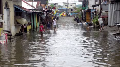 Menschen,-Die-Durch-Die-überfluteten-Slums-Der-Stadt-Surigao-Auf-Den-Philippinen-Laufen