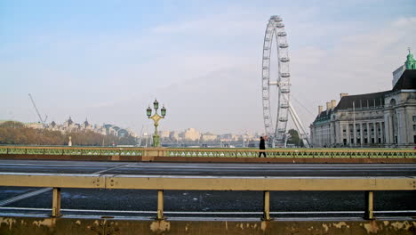 Quiet-and-empty-roads-at-rush-hour-in-London-in-Coronavirus-Covid-19-lockdown-with-deserted-streets-at-Westminster-Bridge-and-London-Eye,-no-traffic-and-one-person-walking-for-rush-hour-commute
