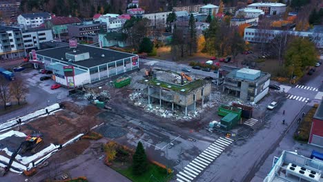 Aerial-view-approaching-excavators-wrecking-a-urban-building---circling,-drone-shot