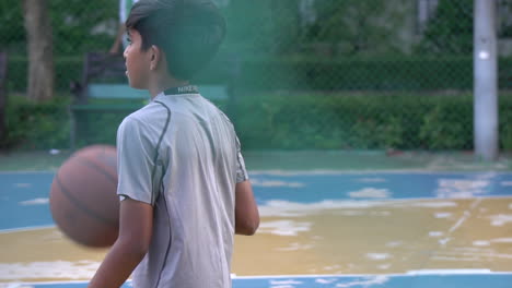 Zeitlupe-Eines-Thailändischen-Jungen-Mit-Ball-Auf-Einem-Basketballfeld-Im-Freien,-Bangkok,-Thailand