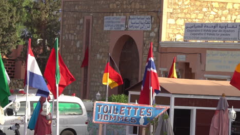 Flags-of-european-flags-and-men-toilet-sign-in-downtown-Essaouira,-Morroco,-slow-motion