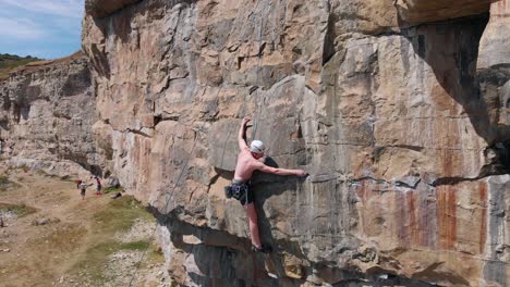 Rock-Climber-Chalking-Hands-on-Steep-Cliff-Edge